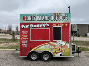 hot dog truck with a blue and red vehicle wrap